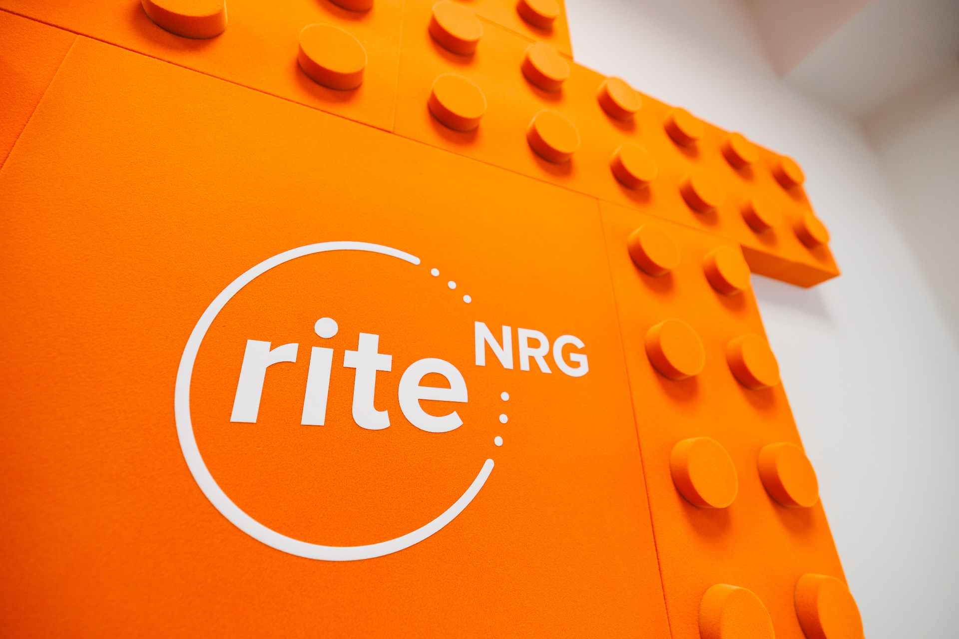 The RITE NRG logo on an orange brick-inspired wall panel in the office