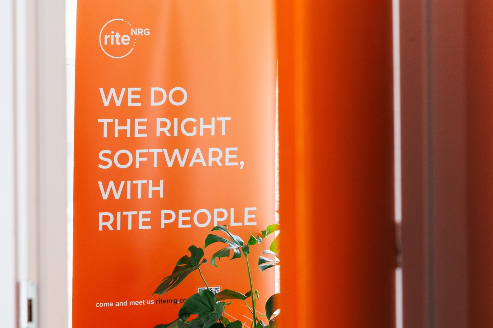 A RITE NRG banner in the office reading: we do the right software, with rite people